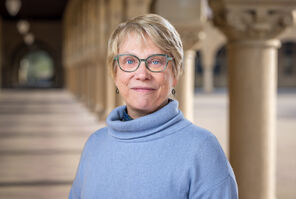 Photo of Martha Cyert with short blonde hair and wearing a light-blue sweater