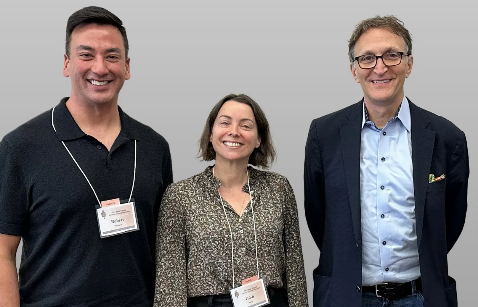 Three people pose for a photo at an event