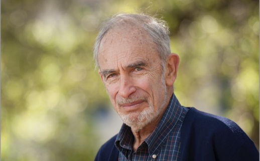 Paul R. Ehrlich standing in front of trees