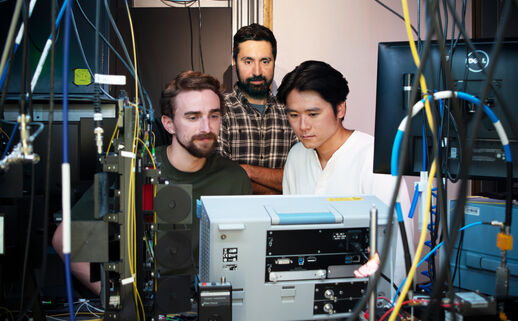 Portrait of the three researchers surrounded by instrumentation.