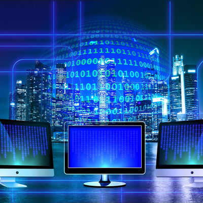 Computer screens, a hologram of a sphere of text in front of a view of a city lit up at night