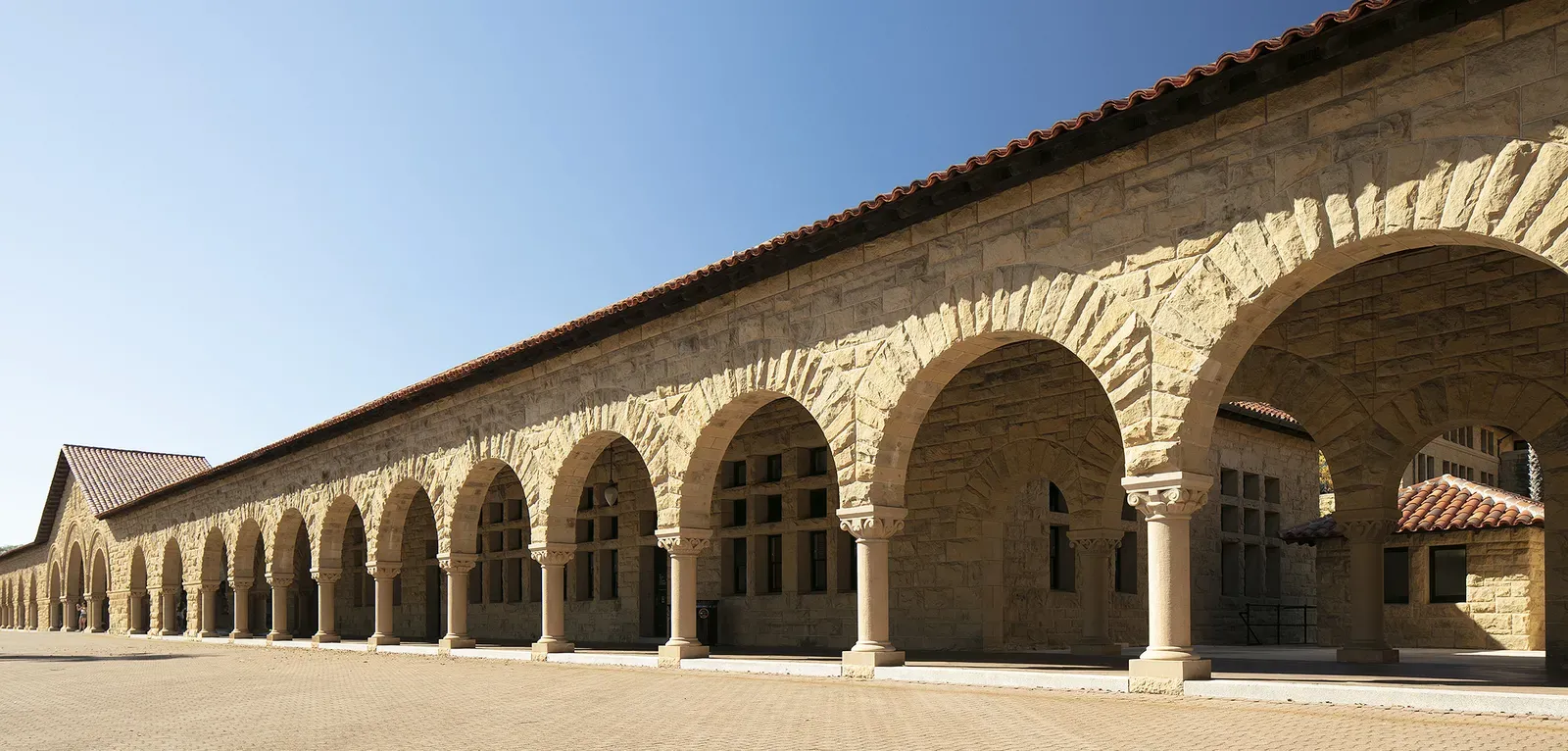 Photo of the span of sandstone arches that constitute the arcade in front of Building 1 facing Stanford's Main Quad