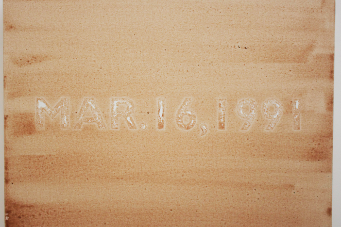 A horizontal canvas covered by orangish brown streaks and the date Mar. 16, 1991 prominently stamped in the middle