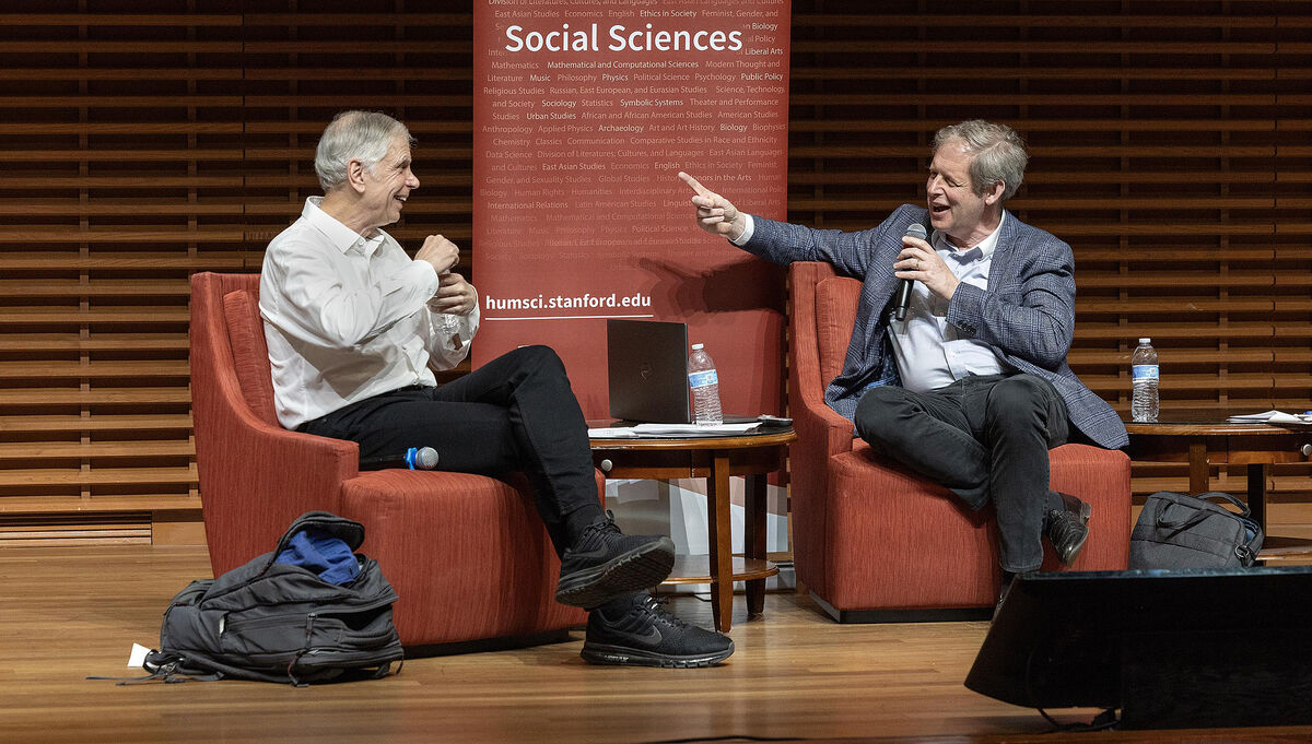 Professor John Donohue and Eugene Volokh discuss gun regulation on stage at CEMEX auditorium