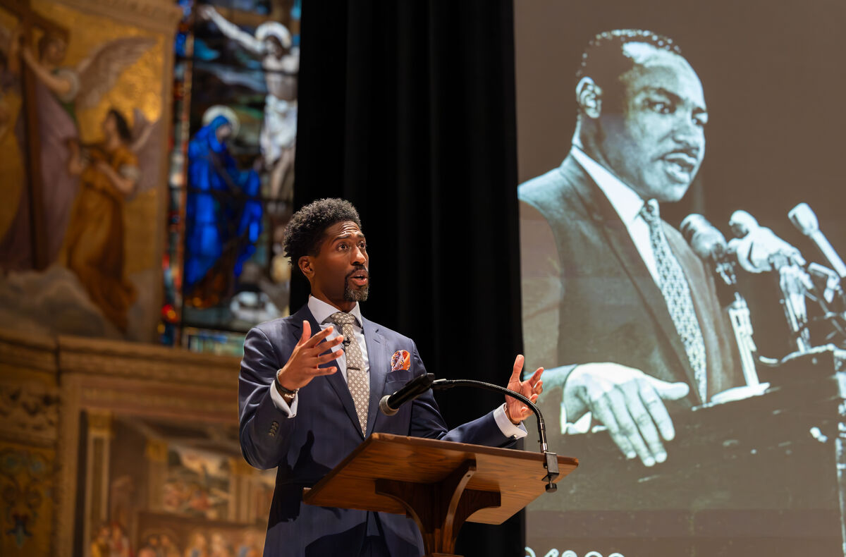 Photo of Lerone A. Martin speaking at the viewing of "Other America" by MLK Jr. at Stanford's Memorial Church
