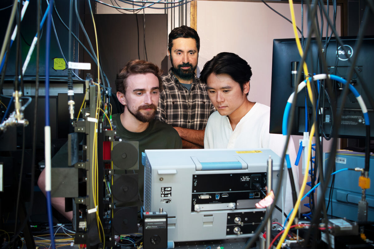 Portrait of the three researchers surrounded by instrumentation.