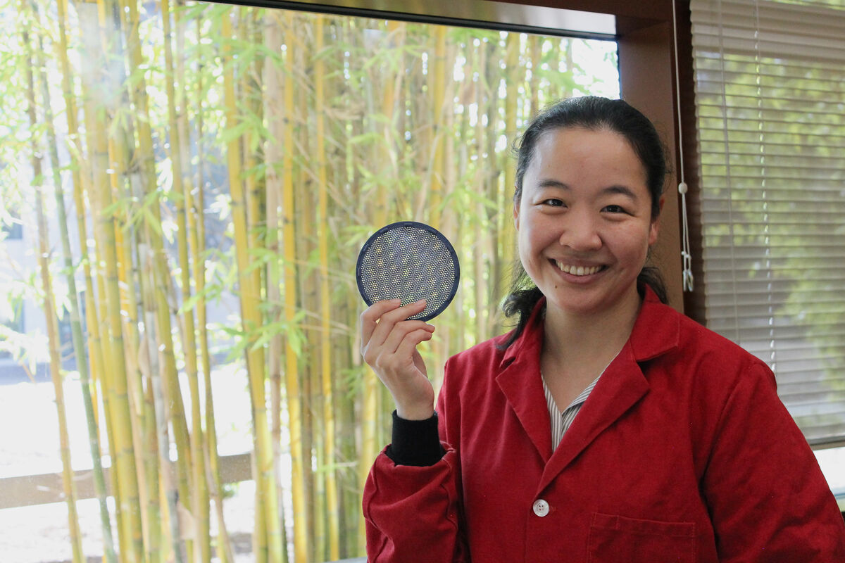Portrait of Fang Liu holding a 3D model of the Moire Lattice