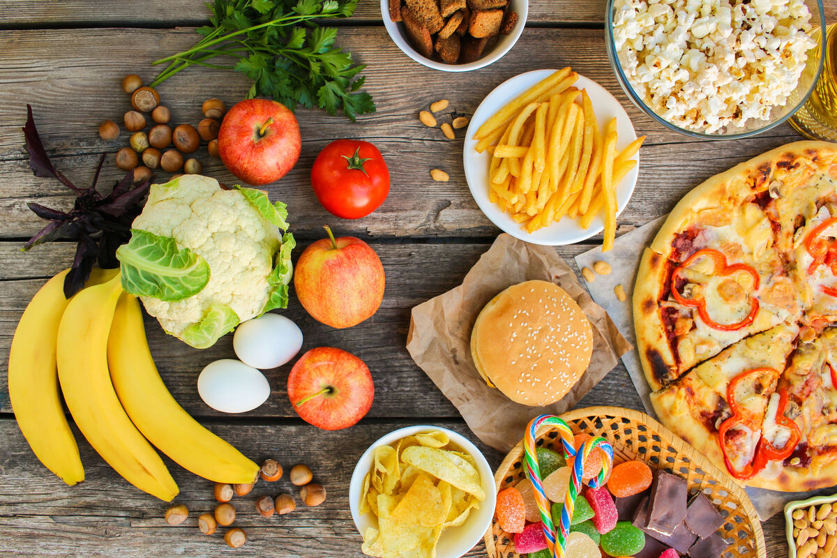 Healthy carbohydrates across a table from unhealthy, processed foods