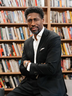 Lerone Martin in front of bookshelves