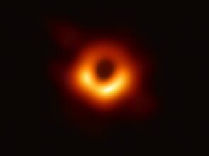 a photo of a black hole with an orange ring around it 