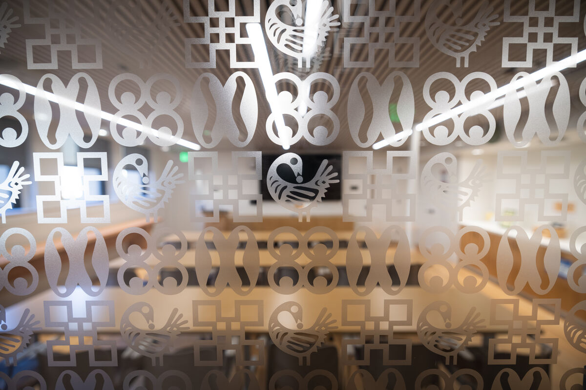 The glass door to a classroom shows etchings of African symbols