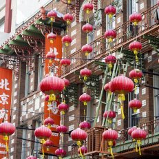 Red paper lanterns strung along the side of a building