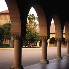 A view through the arches and columns of the arcades onto Stanford University's Main Quad