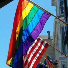 A rainbow flag beside an American flag