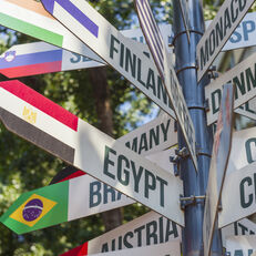 A pole with flags pointing toward the geographic location of named countries