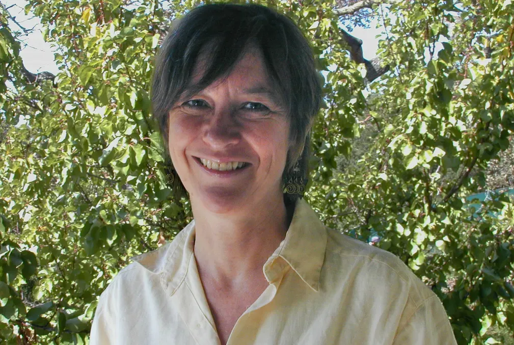 Image of Alice Rayner standing in front of a large tree. 