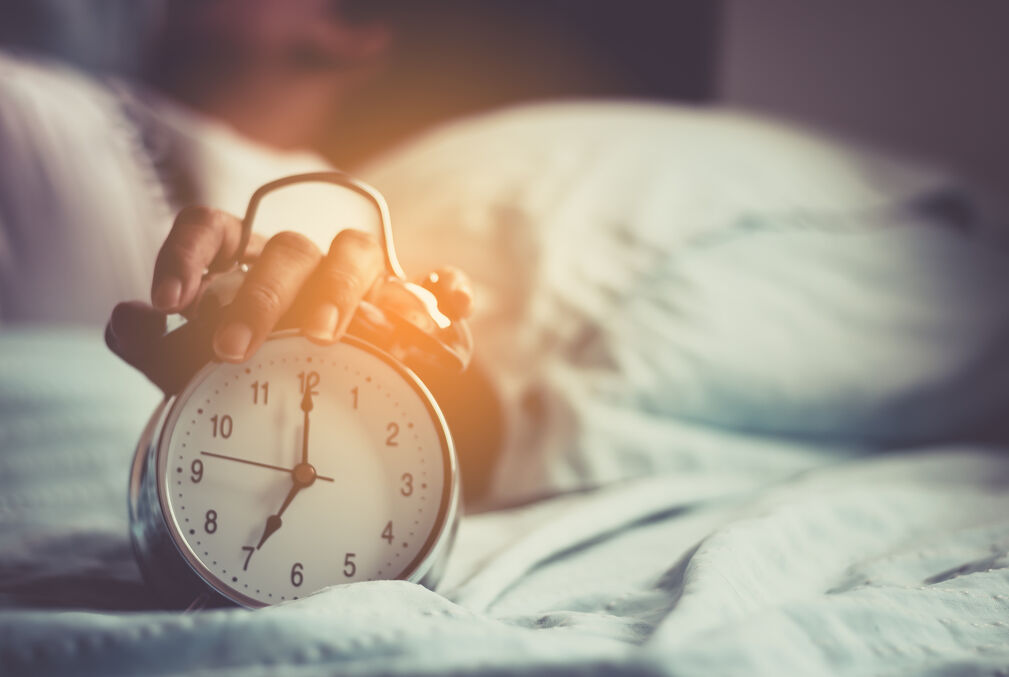 Image of hand on top of alarm clock