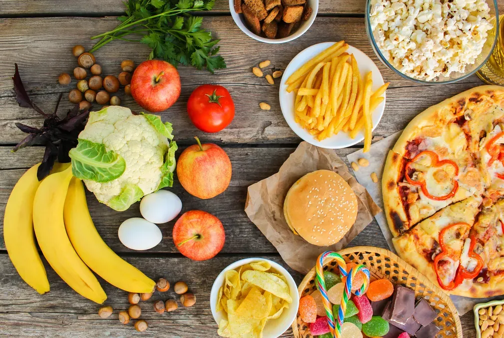 Healthy carbohydrates across a table from unhealthy, processed foods