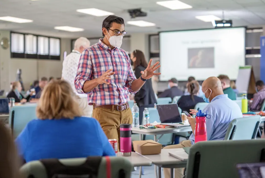 Image of Alex Mahadevan talking in front of a small group at an event.